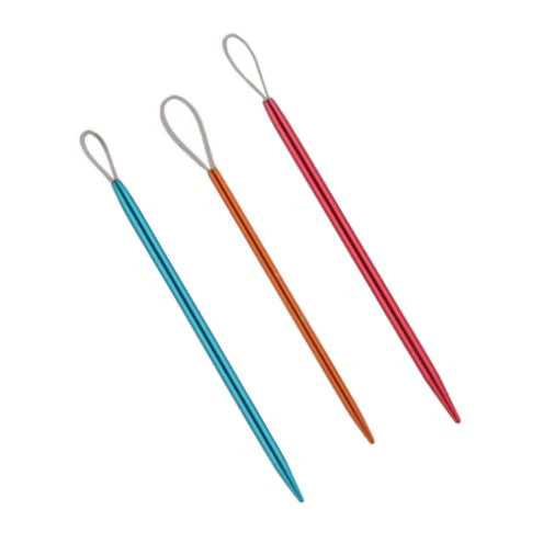 Three metal darning needles of varying sizes. Each needle has a metal body with a blunt tip on one end and a loop of flexible plastic on the other. There is a blue needle of medium thickness, a thin orange needle, and a thick pink needle.