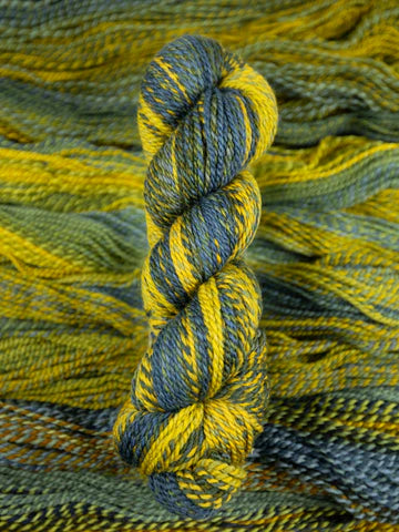 Skein of multicolored handspun looking wool yarn in the colors blue brown grey yellow
