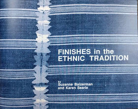 Cover of the book- the background is an indigo and white striped woven tapestry with embroidery along a seam. The title of the book, "Finishes in the Ethnic Tradition" and the authors, "by Suzanne Baizerman and Karen Searle" in white text