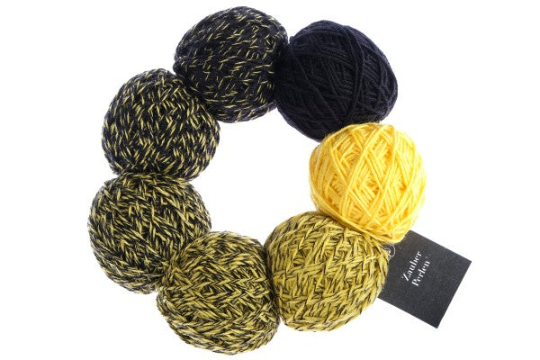 A yellow and white set of Schoppel Zauber Perlen yarn balls