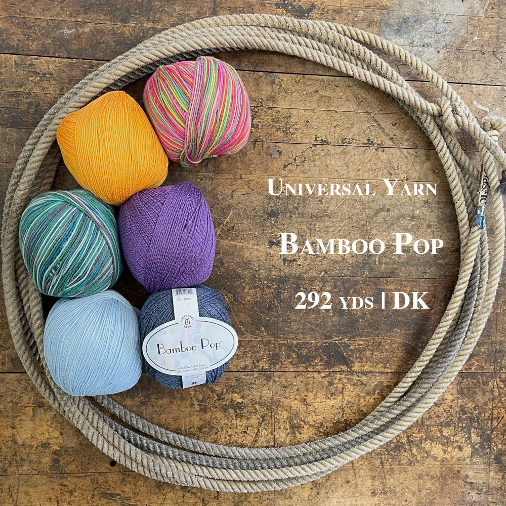 Six colorful balls of Bamboo Pop yarn in a lasso on a wooden surface