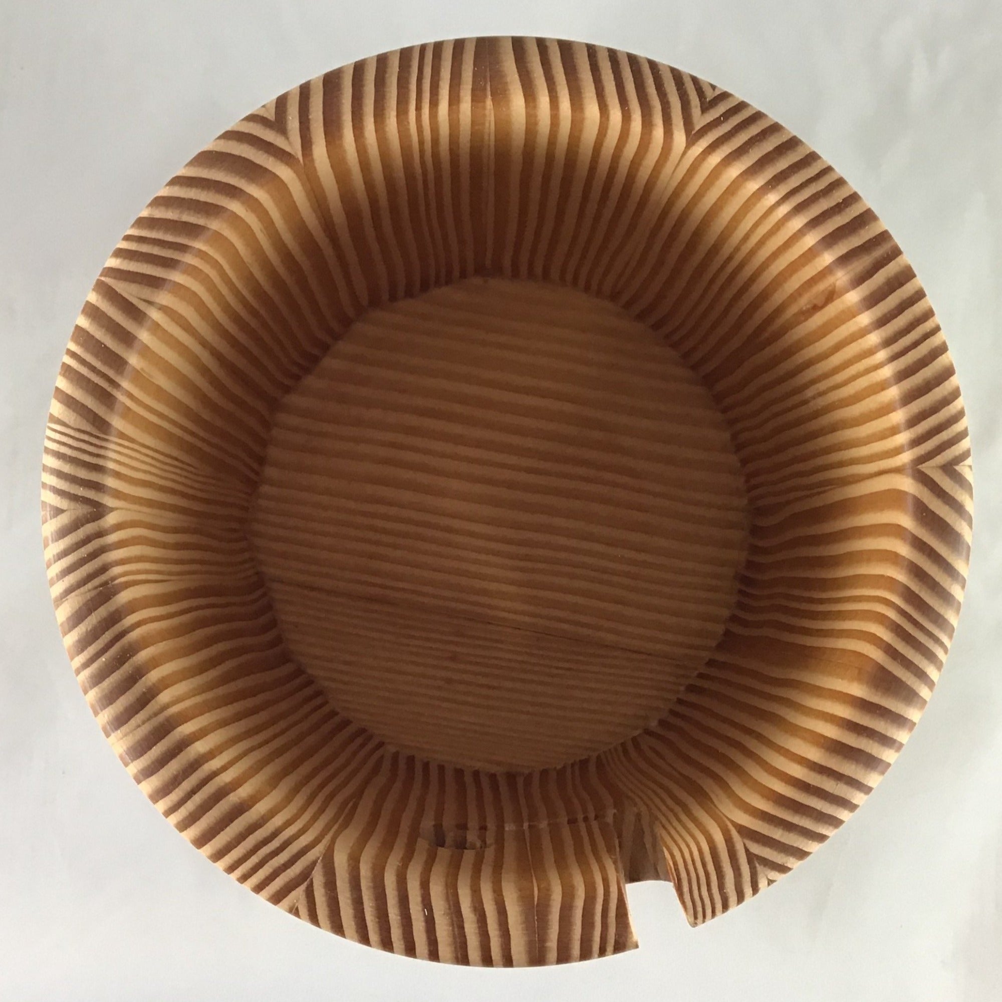  The inside of a wooden yarn bowl made from Douglas Fir wood against a white backdrop