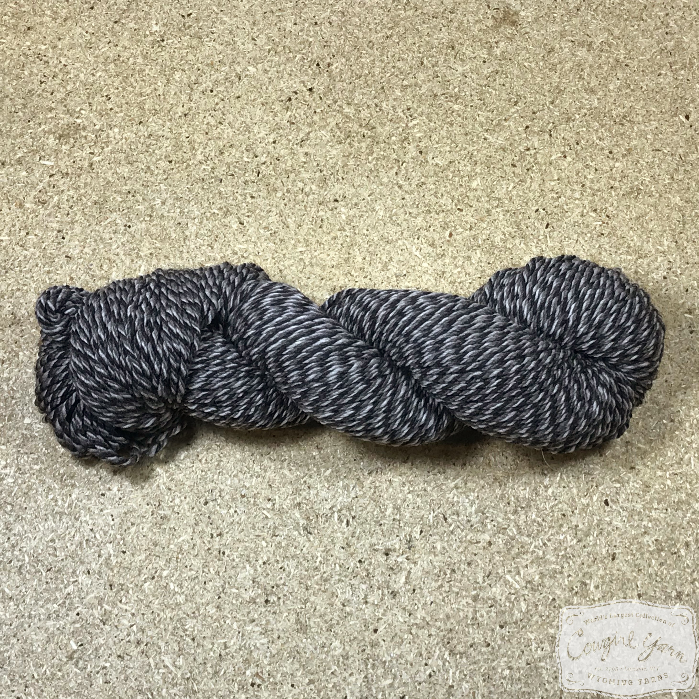 A dark tweed skein of Mountain Meadow Wool Tweed Worsted yarn