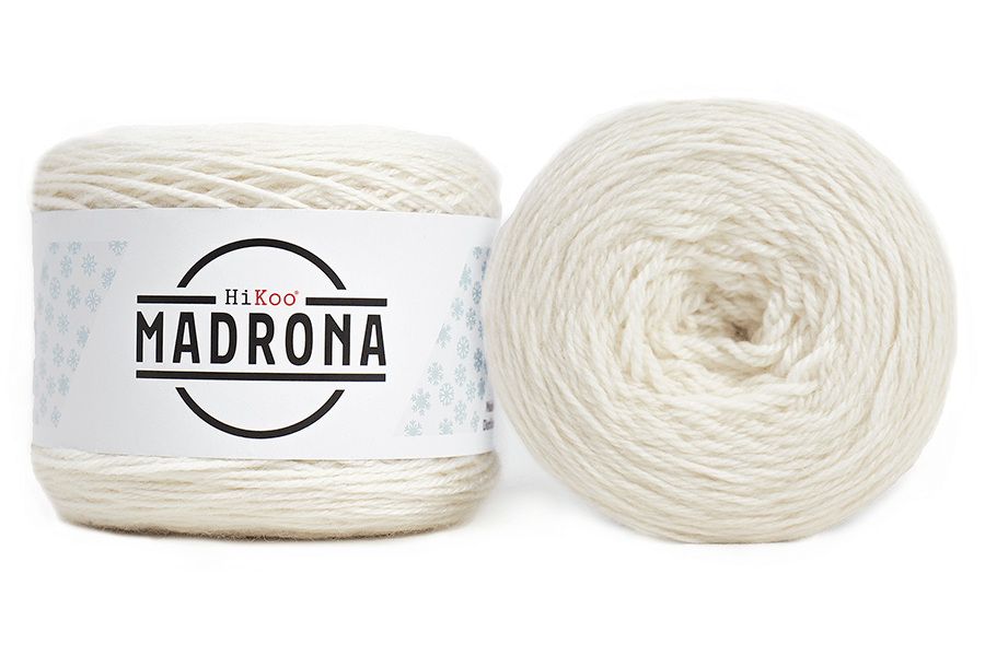 A photo of two white cakes of HiKoo Madrona yarn
