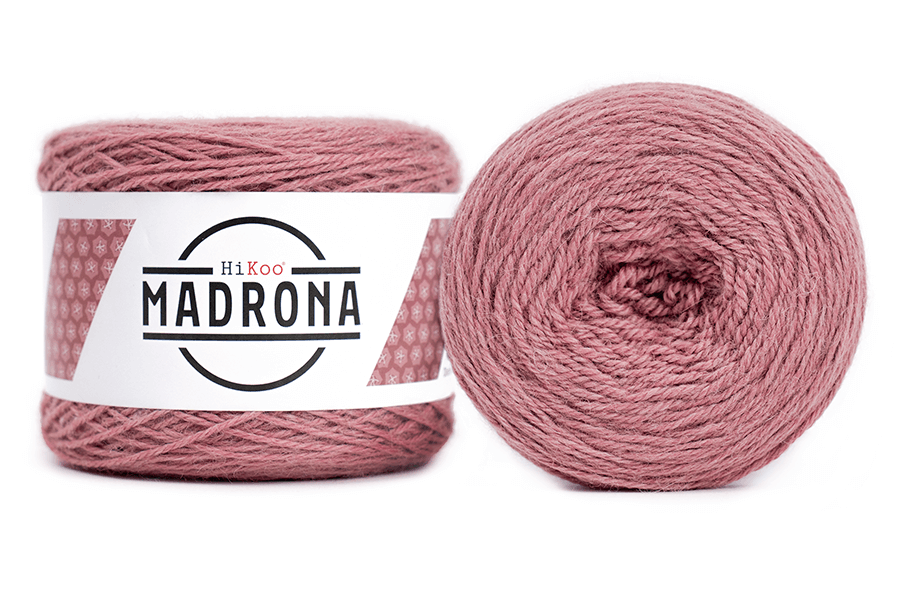 A photo of two light pink cakes of HiKoo Madrona yarn