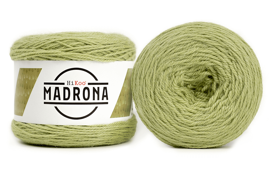 A photo of two light green cakes of HiKoo Madrona yarn