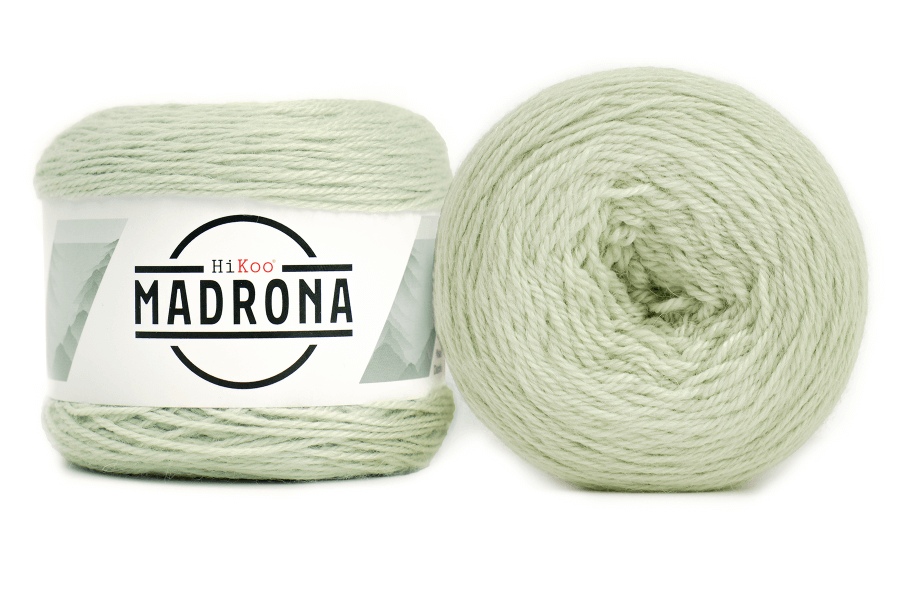 A photo of two light green cakes of HiKoo Madrona yarn