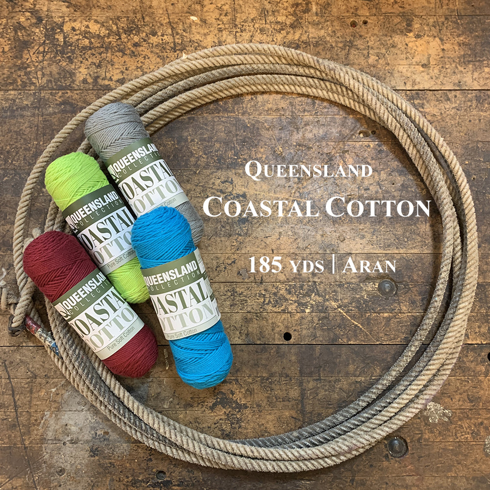 A photo of four colorful skeins of Coastal Cotton in a lasso on a wooden surface