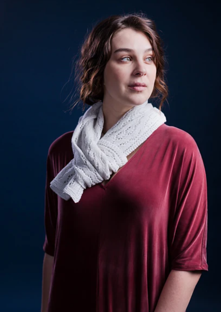 A woman wearing a white, knitted shawl