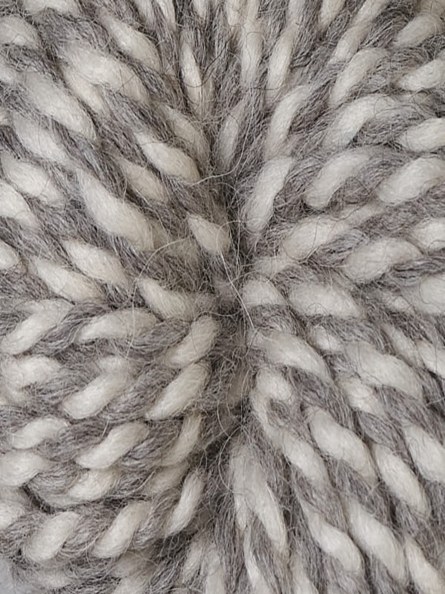 An up close shot of Berroco Ultra Alpaca Chunky Natural in colorway Sunflower Seed, a 2-ply white and light gray yarn
