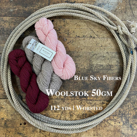 Skeins of Blue Sky Fibers Woolstok wool yarn on a wooden surface