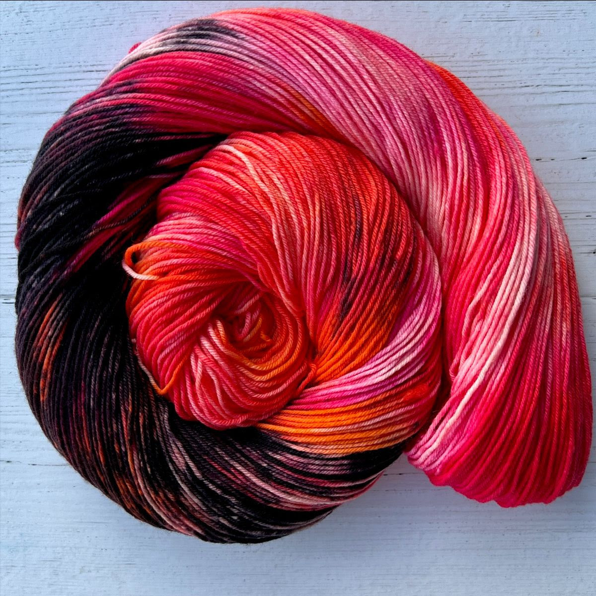 Feb 2023 Herstory: Lilith's Brood, a pink/black/orange skein twisted into a spiral
