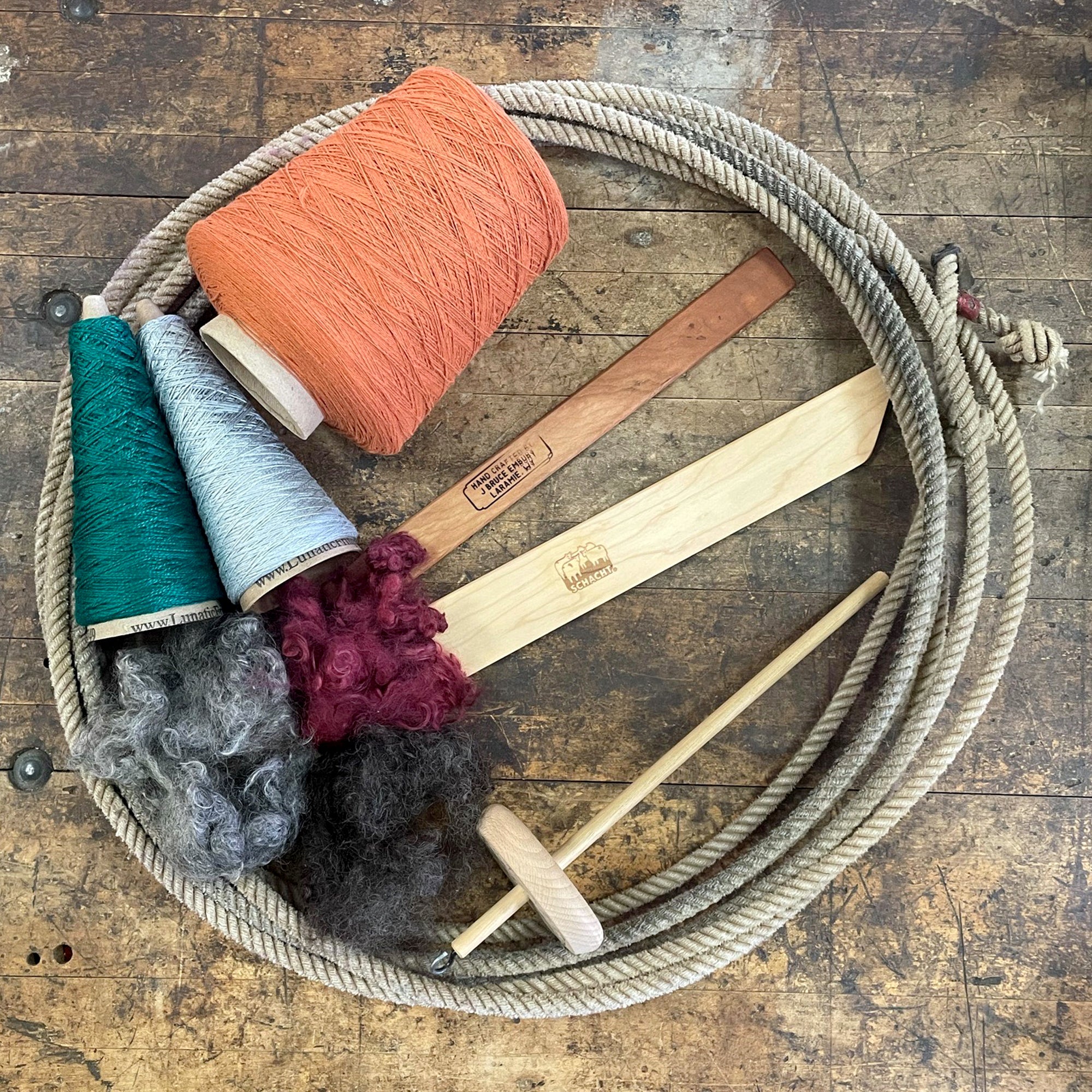 A lariat filled with spinning and weaving tools and fiber