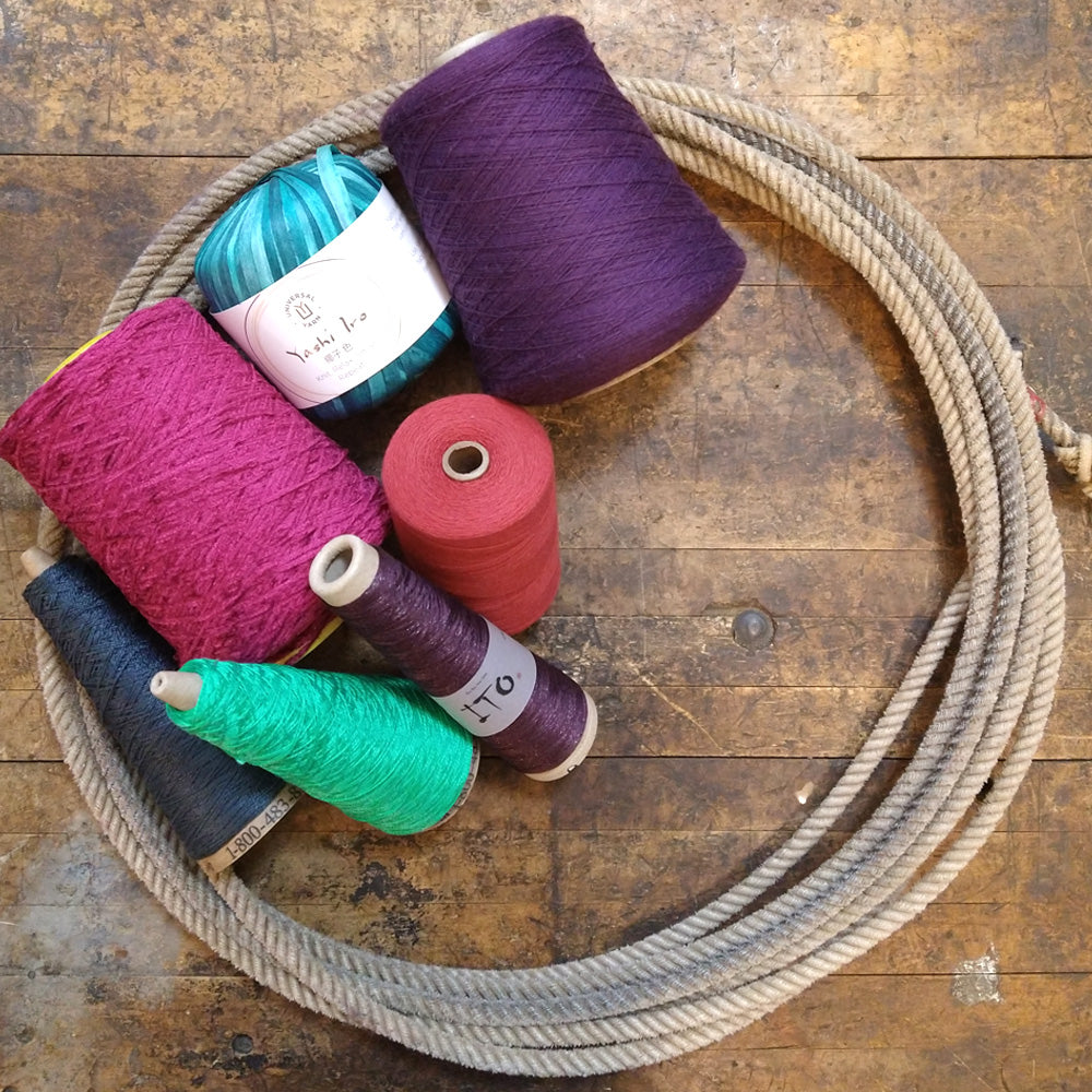 Photo of several cones of colorful yarn.
