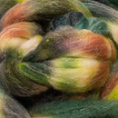 a braid of ready to be spun fiber color green, black, yellow, red