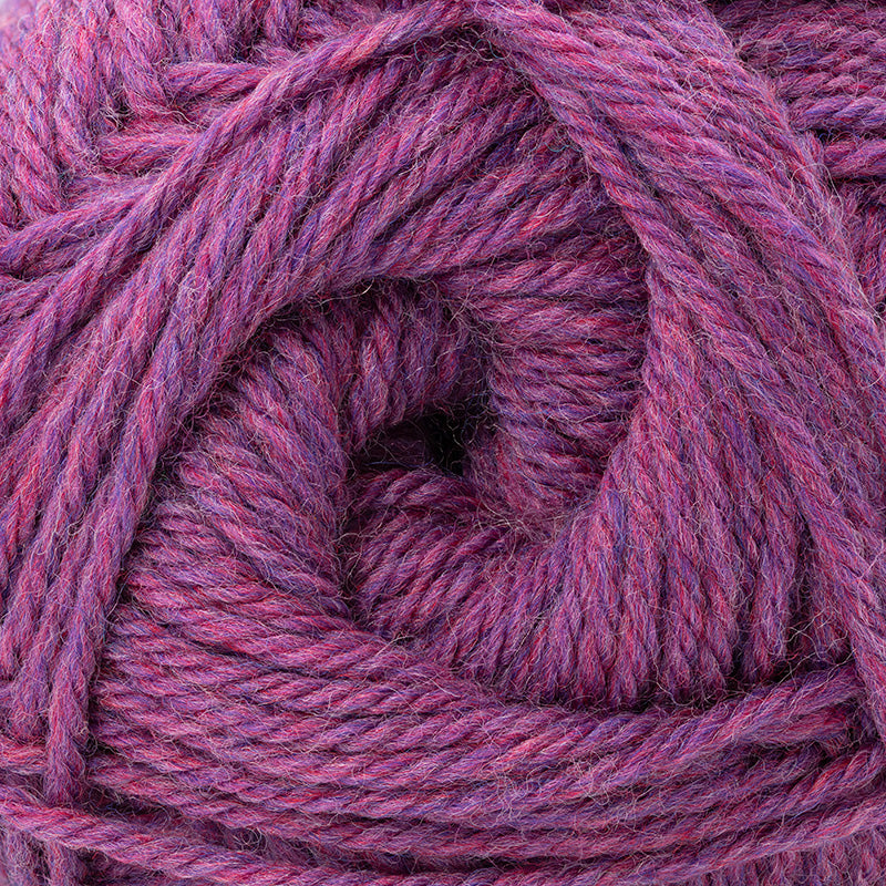 A close-up of twisted yarn wound in a spiral, showing a heathered purple and pink colorway.