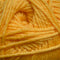 A close-up of soft, twisted yarn in a pale buttery yellow color, filling the entire frame.