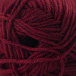 A close-up of a ball of deep burgundy yarn, showing the twisted plies and soft texture of the wool.