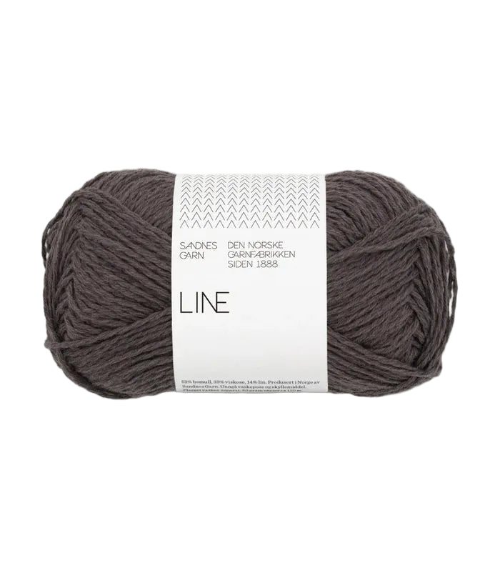 Ball of dark gray yarn with a white label on a white background