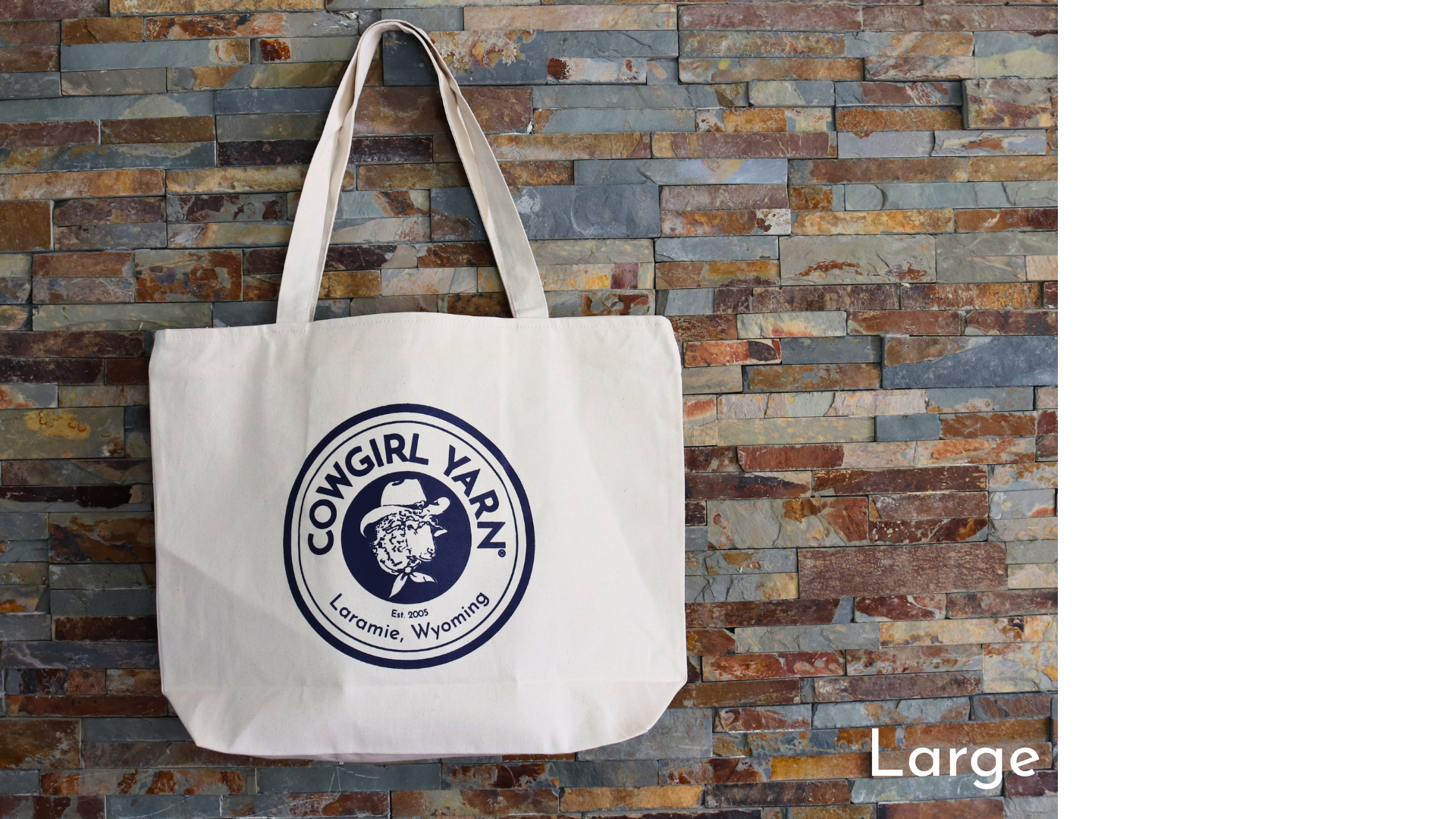 Tote bag with a logo and text against a stone wall background