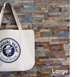 Tote bag with a logo and text against a stone wall background