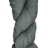 A skein of Berroco Vintage Wool Yarn in the color heathered grey with flecks of sage green and light khaki some navy