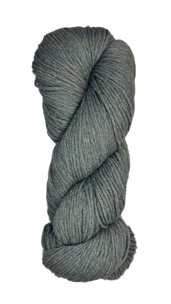 A skein of Berroco Vintage Wool Yarn in the color heathered grey with flecks of sage green and light khaki some navy