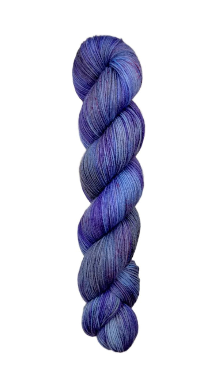 A skein of hand-dyed fingering/sock yarn color grey blue purple speckles