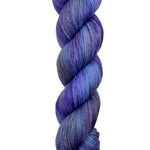 A skein of hand-dyed fingering/sock yarn color grey blue purple speckles