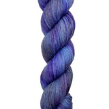 A skein of hand-dyed fingering/sock yarn color grey blue purple speckles
