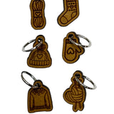 Wooden stitch markers with engraved detail of a sock, hat, mitten, yarn and a sweater