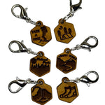 Wooden stitch markers with engraved detail of hiking boots, a tent, waterfall and other outdoors type things