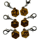 Wooden stitch markers with engraved detail of hiking boots, a tent, waterfall and other outdoors type things