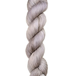 A skein of hand-dyed fingering/sock yarn color grey white 