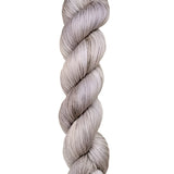 A skein of hand-dyed fingering/sock yarn color grey white 