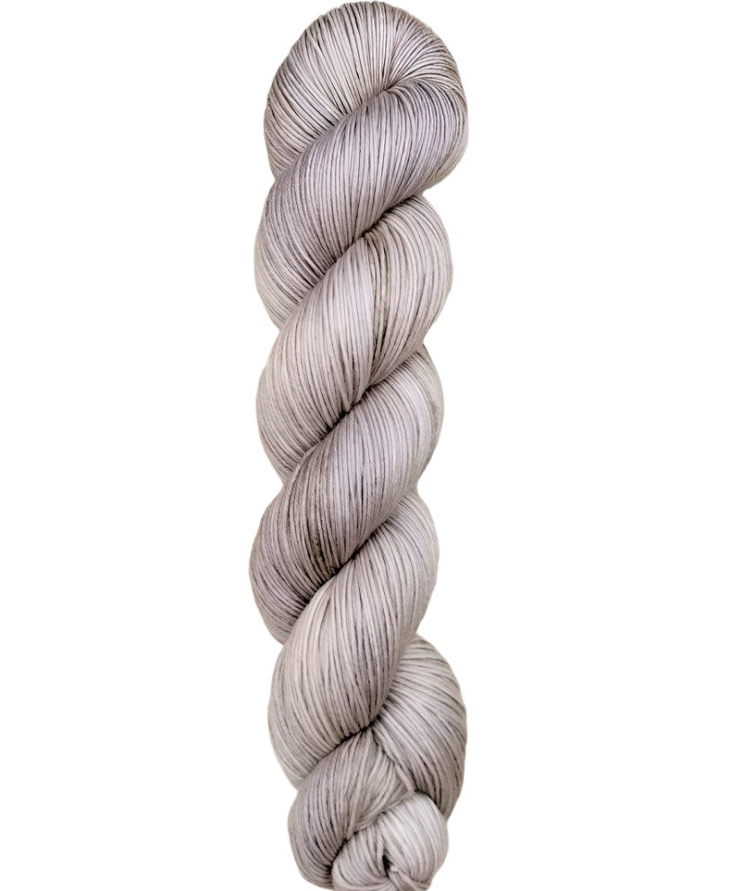 A skein of hand-dyed fingering/sock yarn color grey white 