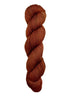 A skein of hand-dyed fingering/sock yarn color auburn burnt orange