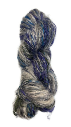 Multicolored skein of handspun yarn in the colors grey blue purple green 