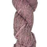Coiled skein of pink yarn on a white background