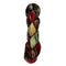 A skein of hand-dyed fingering/sock yarn color brown black red green speckles