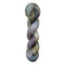 A skein of hand-dyed fingering/sock yarn color white grey tan blue purple black speckles