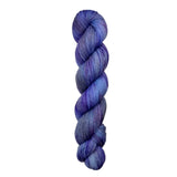 A skein of hand-dyed fingering/sock yarn color grey blue purple speckles
