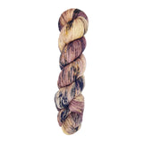 A skein of hand-dyed fingering/sock yarn color mauve off white purple navy black speckles