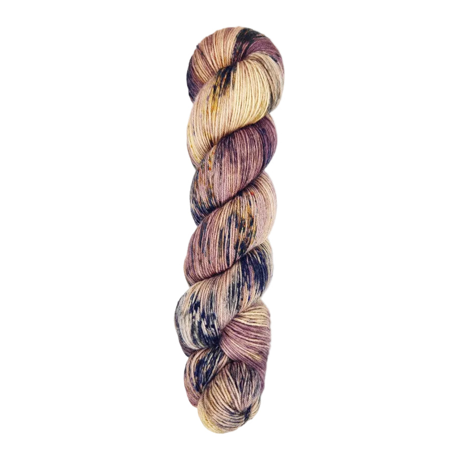 A skein of hand-dyed fingering/sock yarn color mauve off white purple navy black speckles