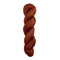 A skein of hand-dyed fingering/sock yarn color auburn burnt orange