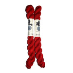 Two red skeins of yarn with a label on a white background