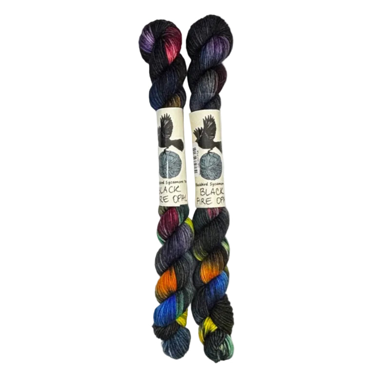 Two mini skeins of wool yarn hand dyed in Wyoming in the color black red orange yellow blue green