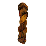 A skein of hand-dyed fingering/sock yarn color burnt orange brown black speckles