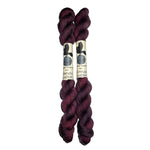 two mini skeins of yarn in a dark wine color