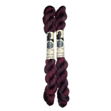 two mini skeins of yarn in a dark wine color